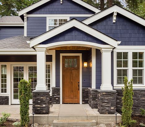 Exterior image of a home displaying columns installed on half walls under a covered porch